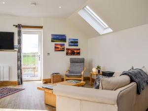 a living room with a couch and a tv at The Old Mill in Fettercairn