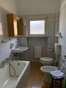 uma casa de banho com uma banheira, um WC e um lavatório. em Amica em Salsomaggiore Terme
