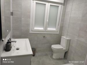 a bathroom with a white toilet and a sink at Piso centro de valdemoro in Valdemoro