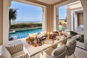ein Esszimmer mit einem Tisch mit Speisen und Meerblick in der Unterkunft Rixos Premium Saadiyat Island - All Inclusive in Abu Dhabi