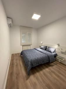 a bedroom with a bed and wooden floors and a window at Piso centro de valdemoro in Valdemoro