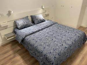 1 dormitorio con 1 cama con manta azul y almohadas en Piso centro de valdemoro, en Valdemoro