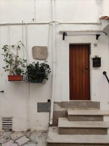 a door on a white building with stairs and plants at La Chianca in Putignano
