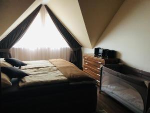 een slaapkamer met een bed en een raam met gordijnen bij Apartment Horec Donovaly in Donovaly
