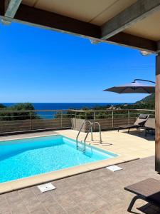 a swimming pool with a view of the ocean at U San Daniellu villas et chambres in Farinole
