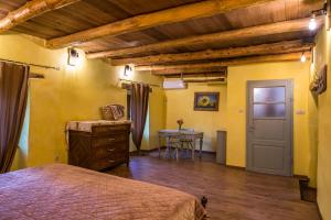 ein Schlafzimmer mit gelben Wänden, einem Bett und einem Tisch in der Unterkunft Šeki Šest in Sočerga