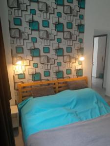 - une chambre avec un lit bleu et un mur avec des places dans l'établissement Kiss-Szőllősi Vendégház II-RAMI, à Debrecen