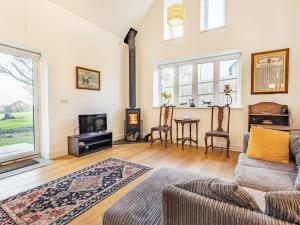 a living room with a couch and a fireplace at Caldbec House Stables in Battle