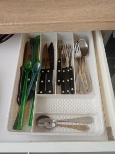 a drawer filled with utensils in a cabinet at Kiss-Szőllősi Vendégház II-RAMI in Debrecen