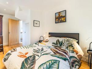 a bedroom with a bed with a colorful comforter at Caldbec House Stables in Battle