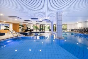 a large swimming pool in a hotel with a ceiling at Mercure Tours Sud in Joue-les-Tours