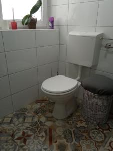 łazienka z białą toaletą i koszem w obiekcie Kiss-Szőllősi Vendégház II-RAMI w Debreczynie