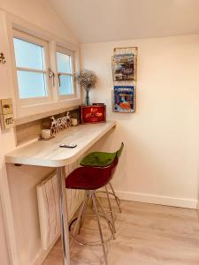 a small kitchen with a desk and a red chair at SHINE CHALET - UNIQUE & COMFORTABLE ACCOMMODATION in Redruth