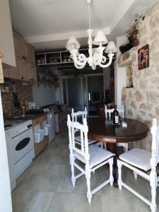a kitchen with a table and two chairs and a chandelier at Stone house Djakonovic in Budva