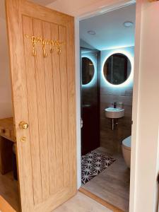 a door to a bathroom with a toilet and a sink at SHINE CHALET - UNIQUE & COMFORTABLE ACCOMMODATION in Redruth