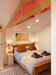 a bedroom with a large bed with orange pillows at SHINE CHALET - UNIQUE & COMFORTABLE ACCOMMODATION in Redruth