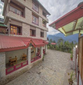 a building with a patio with a table in it at Seechu farm in Pelling