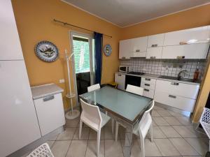 a kitchen with a glass table and white cabinets at Villa Green Place in Mascali