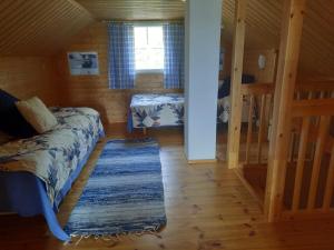 ein Schlafzimmer mit einem Bett und einem Teppich in einem Zimmer in der Unterkunft Holiday Cottage Tiira in Raseborg