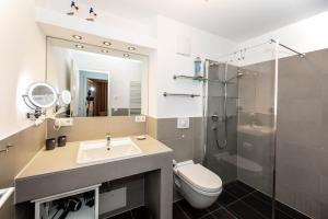 ein Bad mit einem WC, einem Waschbecken und einer Dusche in der Unterkunft Villa Deichgraf 12 "Meerblick" in Börgerende-Rethwisch
