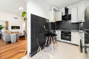 een keuken met witte kasten en een zwarte muur bij House Of Malgosia in Gdańsk
