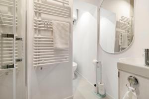 een witte badkamer met een wastafel en een spiegel bij House Of Malgosia in Gdańsk +13 foto's