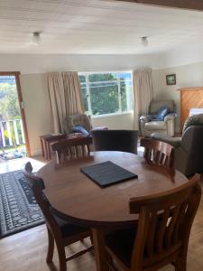 sala de estar con mesa de madera y sillas en Maydena Chalet, en Maydena