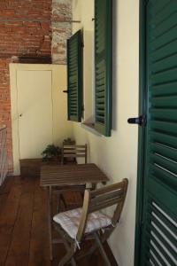 une table et des chaises en bois dans une pièce avec volets verts dans l'établissement B&B Bricco Fiore, à Briaglia