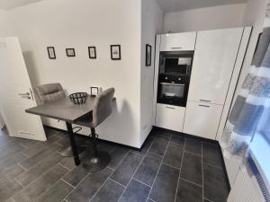 uma pequena cozinha com uma mesa e um frigorífico em TLA TDY Ferienwohnung em Landstuhl