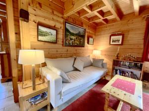 uma sala de estar com um sofá numa cabana de madeira em Chalet Les Carroz d'Arâches, 4 pièces, 8 personnes - FR-1-572-243 em Les Carroz d'Arâches