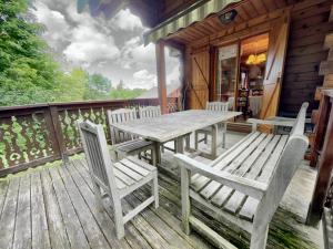 um deque de madeira com uma mesa e cadeiras num camarote em Chalet Les Carroz d'Arâches, 4 pièces, 8 personnes - FR-1-572-243 em Les Carroz d'Arâches