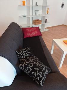 a couch with two pillows on it in a living room at Artbox in Saarbrücken