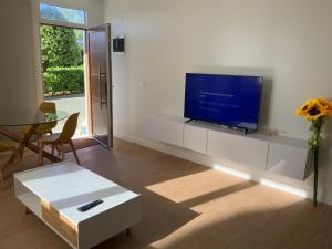 TV a/nebo společenská místnost v ubytování SUPER OFERTA VERANO en la playa apartamento pie de playa YELLOW, un lujo, totalmente nuevo, también para tu mascota