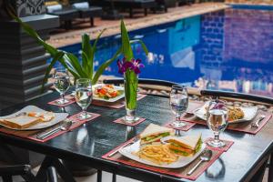 una mesa con platos de comida y copas de vino en The Rabbit Hole Hotel & SPA, en Siem Reap