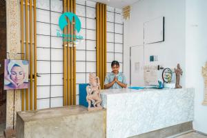 a woman standing behind a counter in a room at The Rabbit Hole Hotel & SPA in Siem Reap