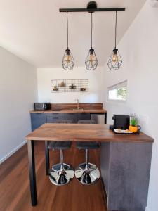 a kitchen with a wooden table and two bar stools at Fully renovated Chalet privatif suite romantique love balneo in Le Castellet