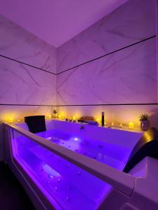 a purple room with a large tub with lights at Chalet privatif / suite romantique love balneo in Le Castellet