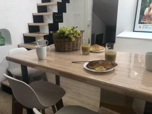 una mesa con un plato de comida y dos vasos de zumo de naranja en Au coeur de ville avec terrasse, en Céret