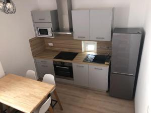 una piccola cucina con tavolo e frigorifero di Au coeur de ville avec terrasse a Céret
