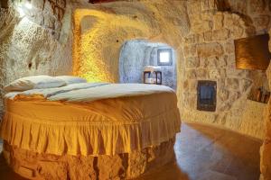 a bedroom with a bed in a stone room at Saliche Cave Suite in Nevsehir