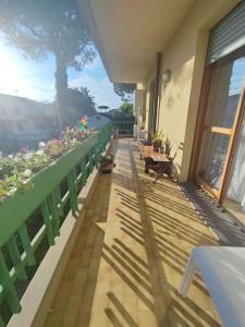 een balkon met tafels en bloemen in een gebouw bij Appartamento Mare e Monti a Marina di MASSA in Massa