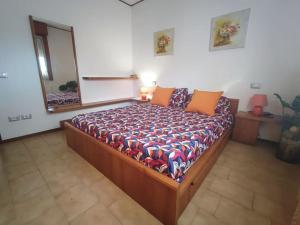 een slaapkamer met een bed in een kamer met een spiegel bij Appartamento Mare e Monti a Marina di MASSA in Massa