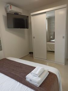una camera da letto con un grande specchio e un letto con asciugamani di Pousada Harmonia Pomerana a Pomerode