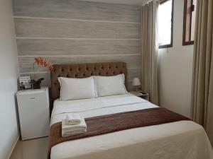 a bedroom with a large bed with two towels on it at Pousada Harmonia Pomerana in Pomerode