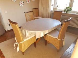 a dining room table and chairs with a white table and chairsktop at Ferienwohnung Silk in Niederkrüchten