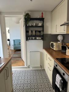 a kitchen with white cabinets and a black and white tile floor at Avocet House Hunstanton 250m from the sea in Hunstanton
