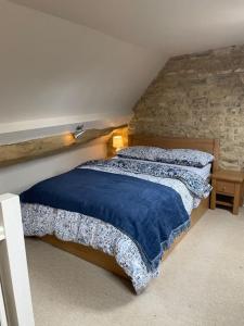 a bedroom with a bed with blue comforter at Honey Cottage, Halford (Annex cottage) in Halford