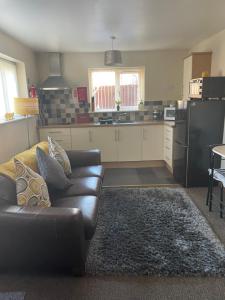 a living room with a couch and a kitchen at Albion Cottages in Bridlington