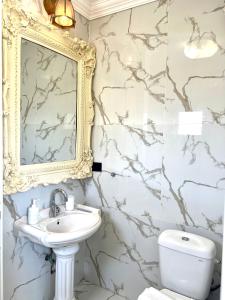 ein Badezimmer mit einem Waschbecken, einem Spiegel und einem WC in der Unterkunft Shantell Luxury Apartment in Netanya