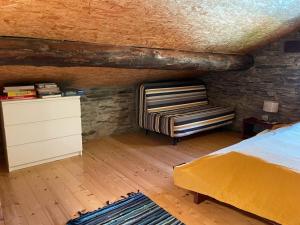 ein Schlafzimmer mit einem Bett, einer Kommode und einem Stuhl in der Unterkunft Rustico a Roveredo GR in Roveredo